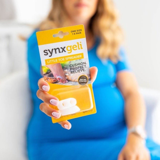 lady holding packet of synxgeli little toe spreader to separate the smaller toes, reducing corn & callus formation