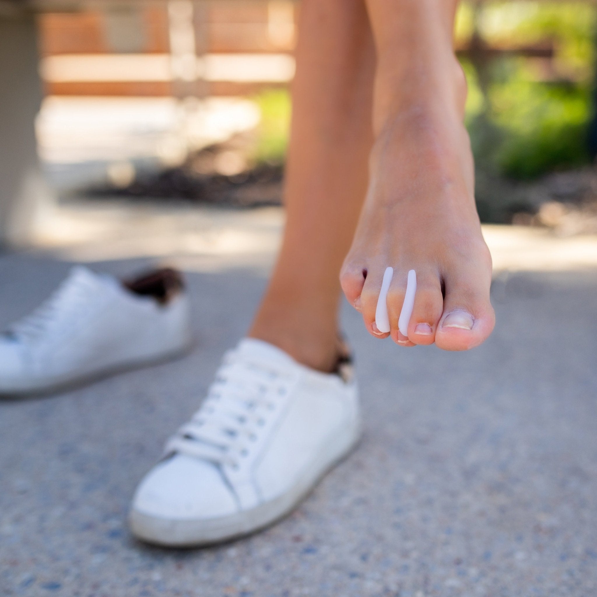 top view of lady wearing synxgeli toe separators to treat corns between the toes or pain caused by overriding or crowding toes