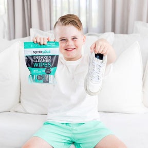 boy holding up sneakers and synxplus sneaker cleaner wipes, microdots wipes, clean sneakers, keep kicks clean, shoes, sneakers