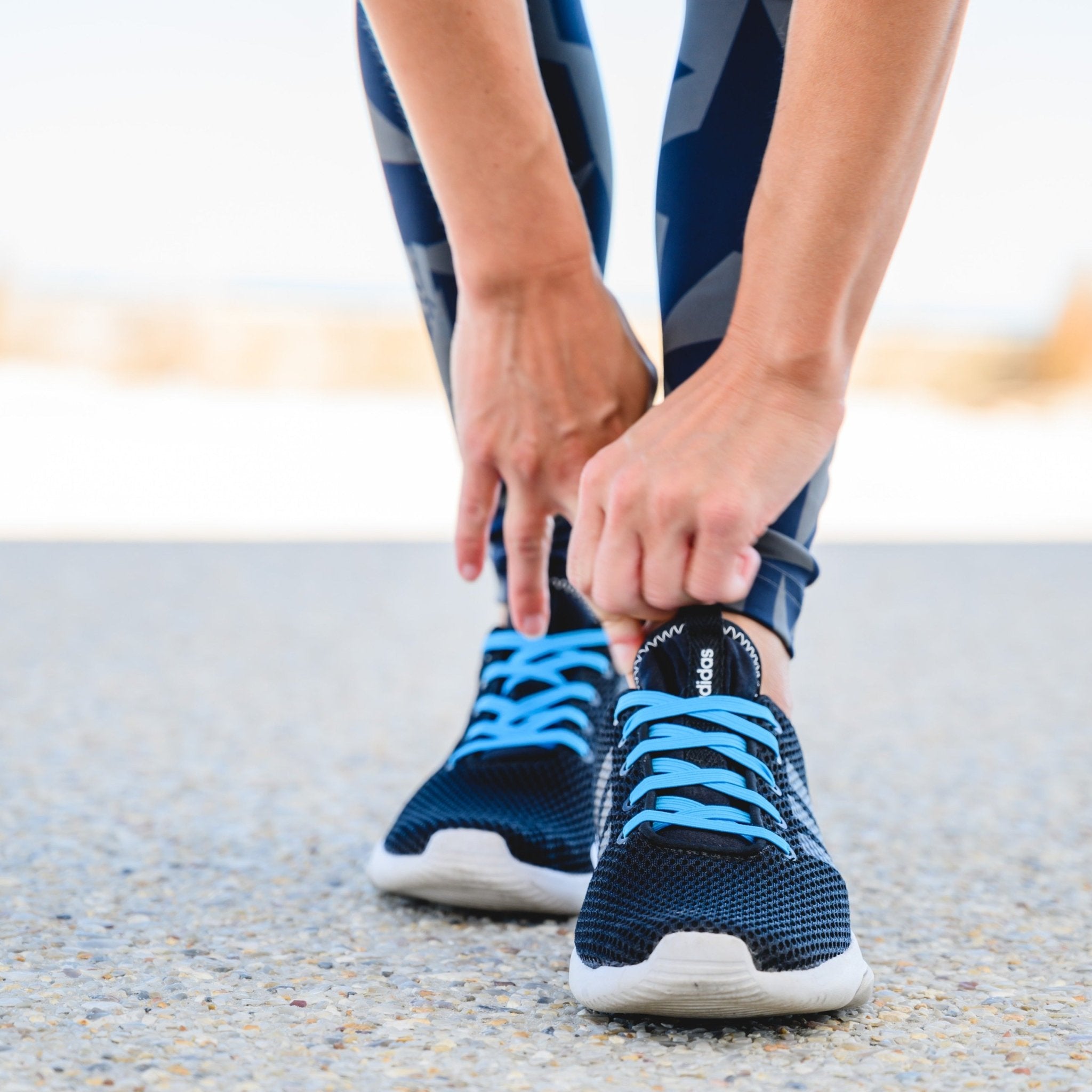 sportwoman bending over pulling on her sneakers with synxlace no tie laces, easy to fit, durable elastic, wide range of colours, suitable for everyone of any age and for all activities including running, cycling, hiking and walking