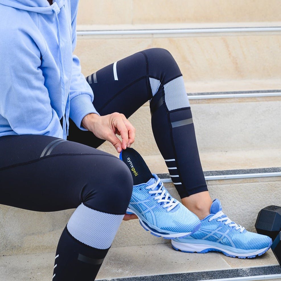 lady inserting synxgeli power insole into sneakers to cushion, protect and relieve the soft tissue and joints