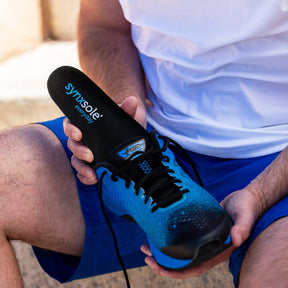 man inserting synxsole one stop insole into sneaker, align the body, support feet, support lower limbs, protect joints