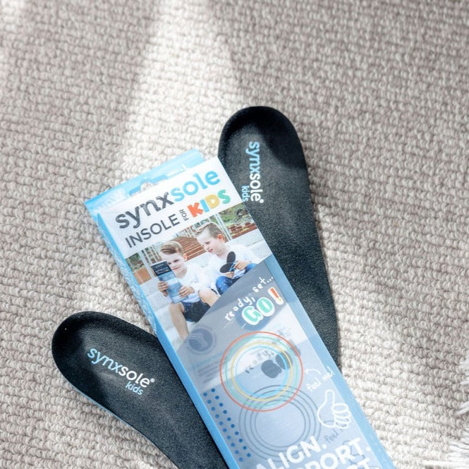 packet of synxsole insoles with insoles laying on carpet, severs disease, growing pains