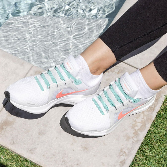 lady wearing white sneakers with turquoise synxlace no tie laces, easy to fit, durable elastic, wide range of colours, suitable for everyone of any age and for all activities including running, cycling, hiking and walking