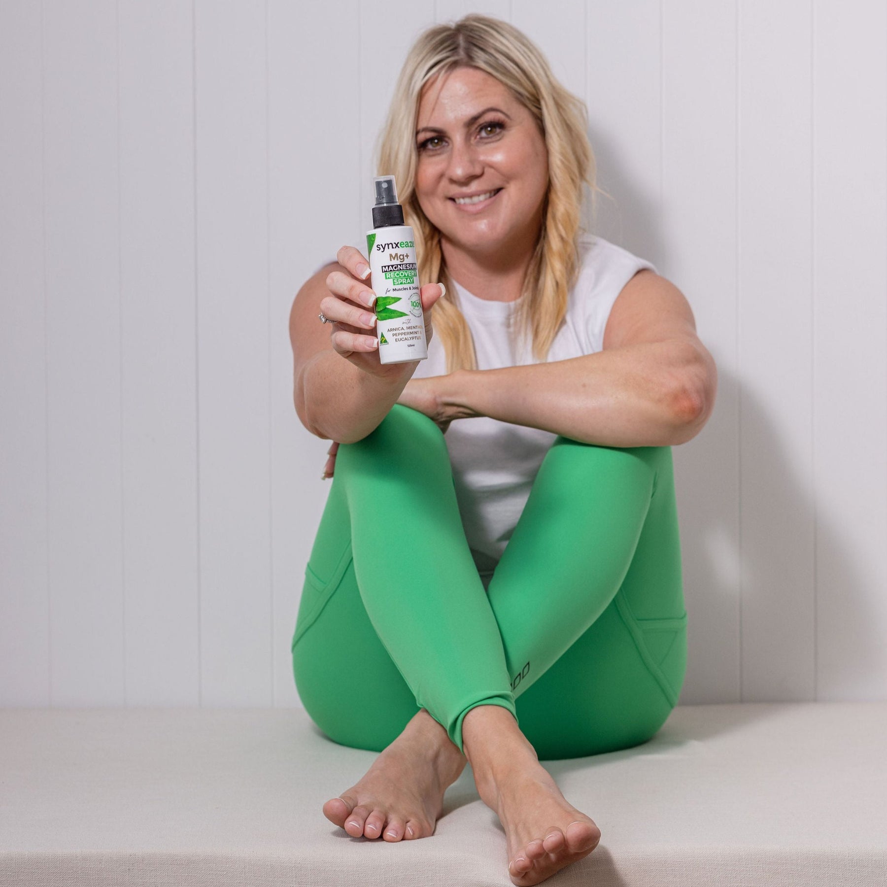 lady holding bottle of synxeaze magnesium spray, active people, maintain flexible and relaxed muscles