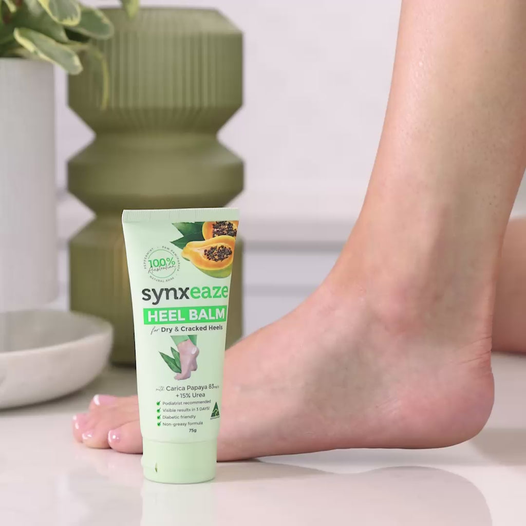 video lady applying synxeaze heel relief balm tube with papaya and AHAs to moisturise dry and cracked heels