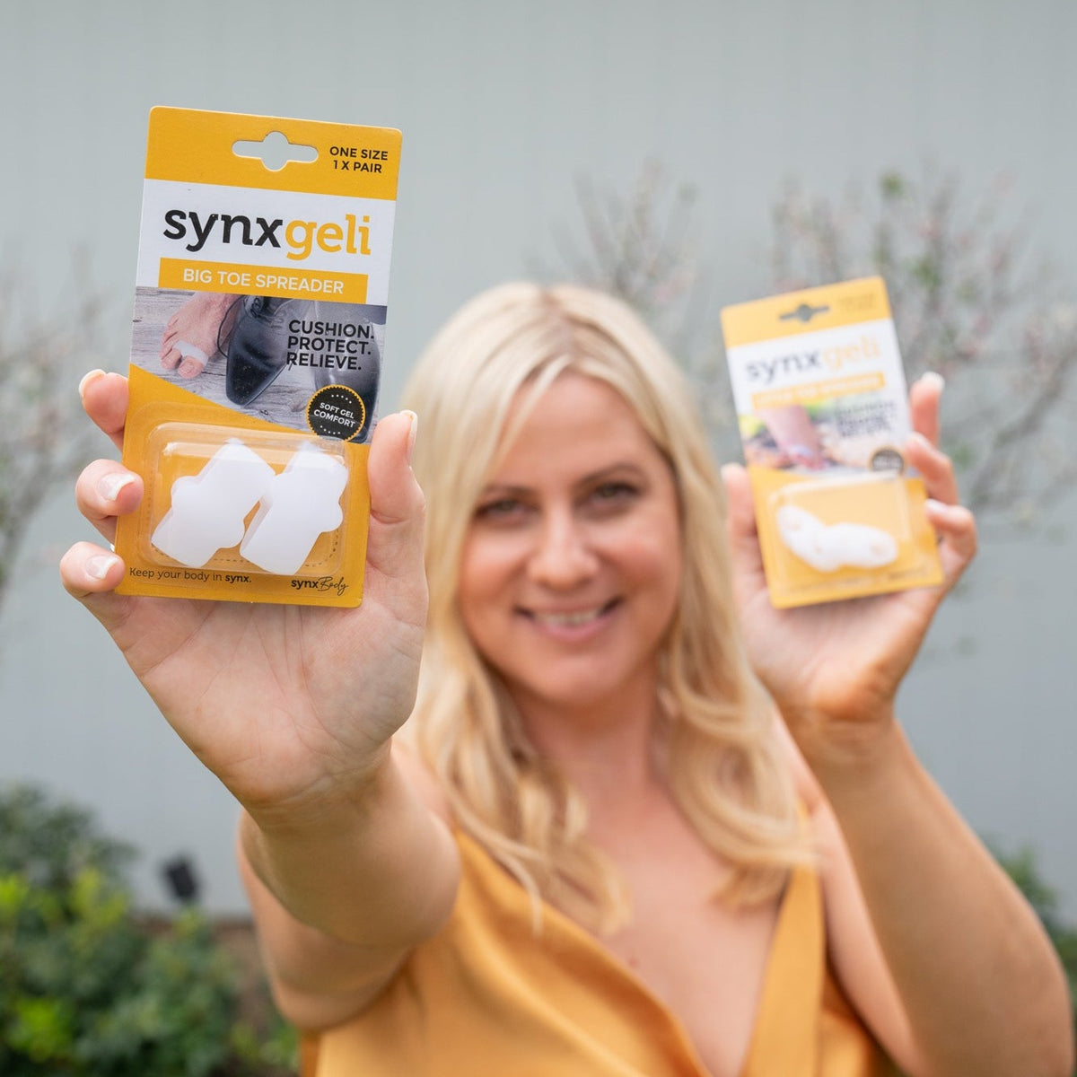 lady holding up packet of synxgeli big toe spreaders to prevent callus and corn formation