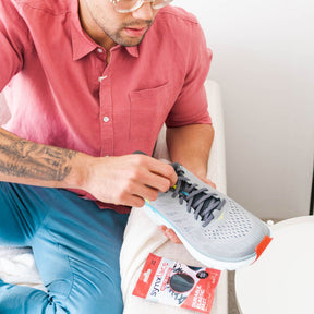 man lacing up sneakers using synxlace no tie laces in grey, easy to fit, durable elastic, wide range of colours, suitable for everyone of any age and for all activities including running, cycling, hiking and walking