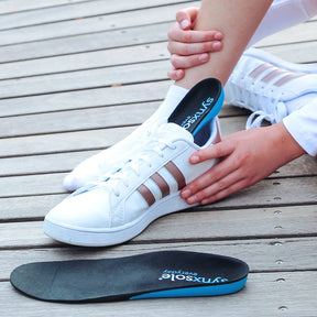 lady inserting synxsole one stop insole into sneaker, align the body, support feet, support lower limbs, protect joints